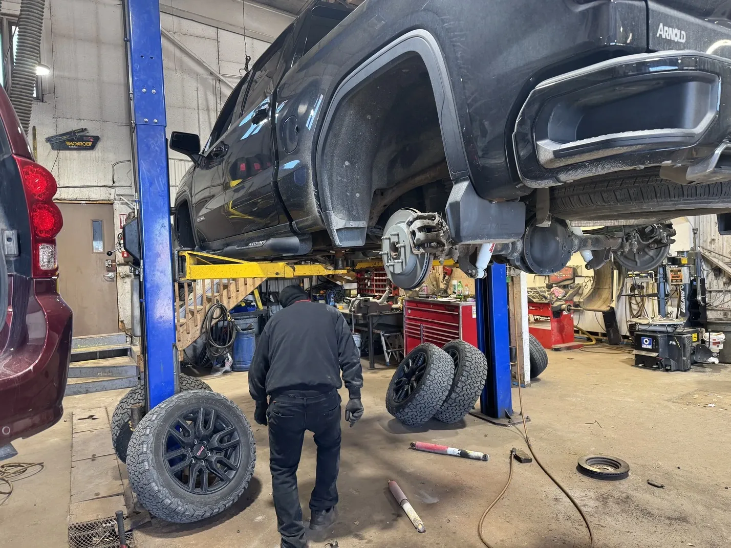 L'atelier de DG Pneus Mécanique et Pare-brise à Jonquière, avec un camion levé sur le pont